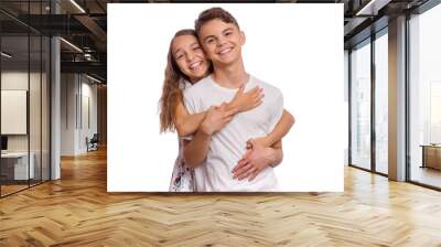 Sweet young couple in love. Happy teenagers standing together and hugging, isolated on white background. Teen girl smiling and hugging her boyfriend. Concept about love, people and lifestyle. Wall mural