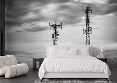 A black and white moody atmospheric shot of two cellular network towers and overhead power cables. Urban street furniture with copy space to left. Wall mural