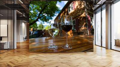 pair of white and red wine glasses on a wooden table close up selective focus, against old Canadian winery vineyard farmhouse cellar and tasting room Wall mural