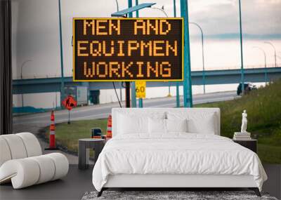 Temporary condition Variable message sign with orange barrels on the right roadside, Men and equipment working, work zone on the Canadian roads Wall mural