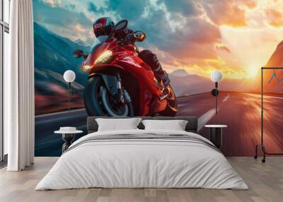 A motorcyclist in a protective red leather suit and helmet rides a sports motorcycle. A biker rides along the road against the backdrop of sunset. Wall mural