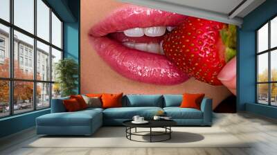 Attractive woman tasting cherry and strawberry. Beautiful woman with fashion makeup and a vivid background. Wall mural