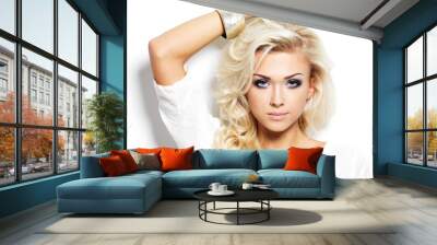 Beautiful blond woman with long curly hair and style makeup. Wall mural