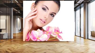 Beautiful face of  woman with healthy skin and pink flowers Wall mural