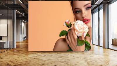 Beautiful white girl with rose.  Stunning brunette girl with white flower. Closeup face of young beautiful woman with a healthy clean skin. Pretty woman with bright makeup Wall mural