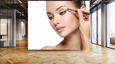 Beautiful woman applying eyeshadow use makeup brush Wall mural