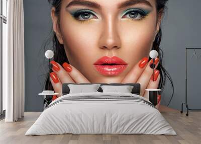 Beautiful woman with bright red lipstick and  nails. Gorgeous girl with blue eye makeup. Wall mural