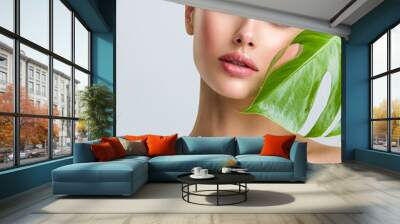 Beautiful woman with green leave near face and body.  Closeup girl's face with green leave. Skin care beauty treatments concept. Wall mural