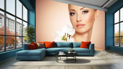 Face of a Beautiful woman with  clean skin and white flower Wall mural