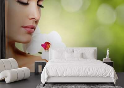 Face of  beautiful woman with a white orchid flower Wall mural