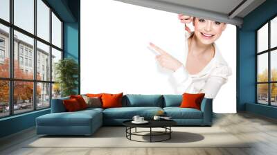 Happy woman points on the white blank banner Wall mural