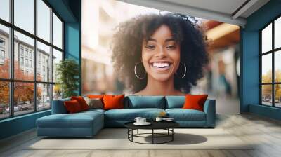 Happy young african american woman smiling in the city. Closeup Portrait of a happy young adult African girl standing on a European city street. African female with perfect white teeth closeup. Wall mural