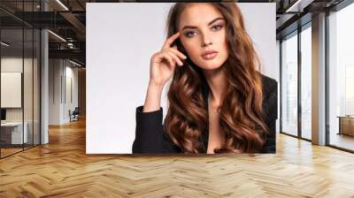 Portrait of a beautiful woman with a long hair in a black clothes. Young brunette woman in black sits on chair. Beautiful fashion model with brown hair, isolated on white background. Wall mural