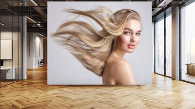 Portrait of a blonde beautiful woman with a long straight light hair. Flying hair. Wall mural