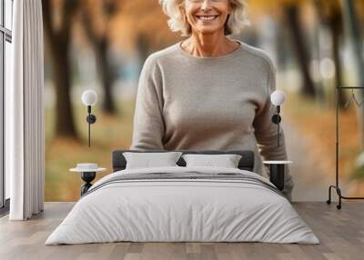 Portrait of a happy senior woman walking in the park in autumn. Active Mature Caucasian woman  with grey hair in the park. Portrait of a smiling senior woman in the park on a sunny day.  Wall mural