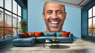 Portrait of a smiling middle aged man with gray hair. Closeup face of handsome middle-aged man smiling at camera on blue background. Front view, happy Muslim man in a blue shirt. Wall mural