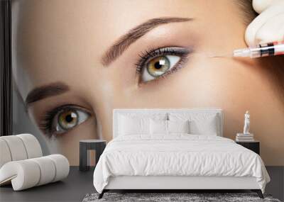 Woman getting cosmetic injection of botox near eyes Wall mural