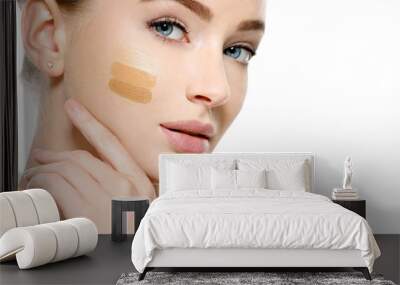 Young woman with cosmetic foundation on skin. Wall mural