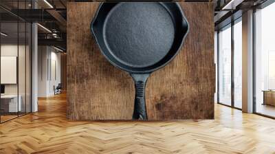 Vintage cast iron skillet  on rustic wood background. Wall mural