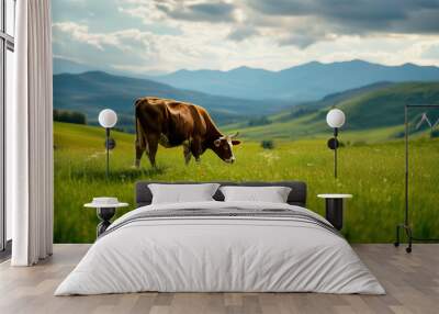 A peaceful rural landscape with a brown cow grazing on a vibrant green meadow Wall mural