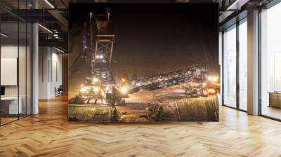 Heavy mining equipment at work in an open-pit mine at dusk. Wall mural