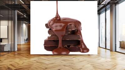 Chocolate pieces stack and chocolate syrup isolated on white background. Close up. Wall mural