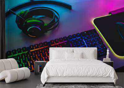 Gear equipment at gamer workspace - Rgb, keyboard, headphones and mouse Wall mural