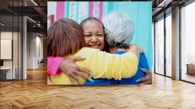 Happy diverse senior people hugging each other outdoor - Older friends community concept - Focus on African woman face Wall mural