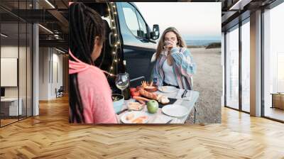 Multiracial happy friends eating vegan food in front of camper van in mountains - Focus on right girl Wall mural