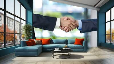 Two businessmen shaking hands in a modern office, representing a successful business merger. concept of partnership, collaboration,professional achievement Wall mural