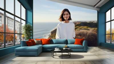 Sweatshirt mockup a portrait photograph of a beautiful woman female standing outside in nature on a hill above the ocean beach sea Wall mural