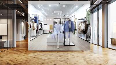 Interior of clothing store .Bright interior.Minimalistic style.Clothes hang on hanger.Trendy colors Wall mural