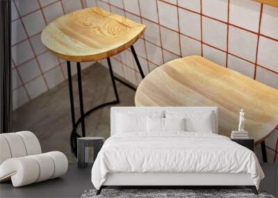 Two Round wooden with metal legs chairs. Against white tiles with orange lines..Stylish. Modern interior of cafe.Authentic style with element of loft.Orange,white and grey colors. Wall mural