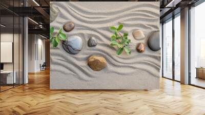 Smooth pebbles and sprigs of greenery arranged artistically on raked sand, creating a tranquil Zen garden pattern Wall mural