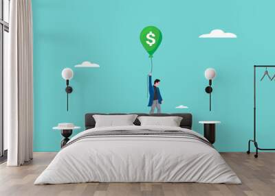 tax burden, business budget barriers, taxation problem for wealth accumulation, businessman fails to fly using a green balloon with a dollar symbol because of the weight ball attached to his feet Wall mural