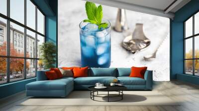 Blue lagoon, Tropical cocktail served with ice cubes decorated with mint. Refreshing alcohol drink for party at summer. Wall mural