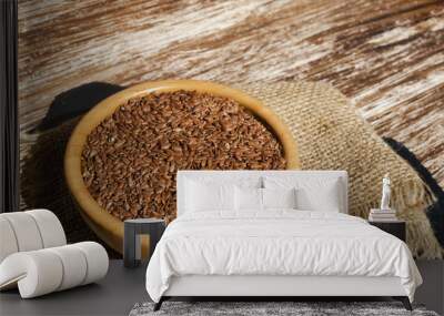 Close up of brown flax seeds  in wooden bowl on a rustic table. Superfood: linseeds are high in omega-3 fatty acids, essential for good health. Healthy eating ,vegan diet concept. Wall mural