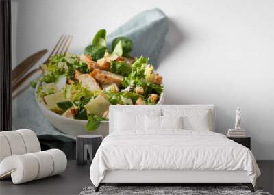 Homemade Caesar salad in the white plate on the white background. Fitness salad with  different lettuce, cheese, croutons, and chicken Wall mural