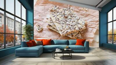 Square crackers with flax, sesame and sunflower seeds on butter papers Wall mural