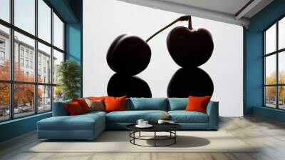 Two cherries with cross stalks and a mirror image on a light blue background with volumetric illumination. Wall mural