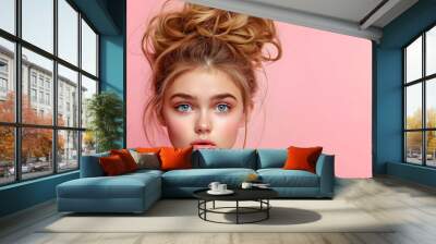 Beautiful young woman with messy bun hairstyle and natural makeup on pink background for beauty and fashion advertising concept with copy space Wall mural