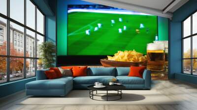 Beer and snacks set on football match tv background Wall mural