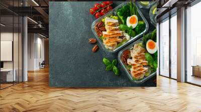 Healthy meal prep containers with green beans, chicken breast and broccoli. A set of food for keto diet in lunchbox on a dark concrete background. Top view with copy space Wall mural