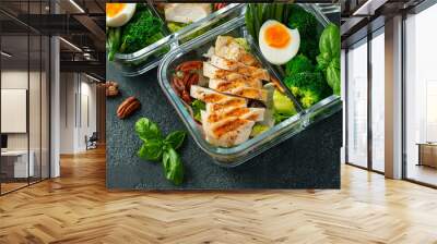 Healthy meal prep containers with green beans, chicken breast and broccoli. A set of food for keto diet in lunchbox on a dark concrete background. Top view Wall mural