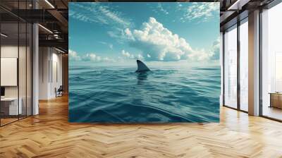 shark fin on surface of ocean agains blue cloudy sky Wall mural