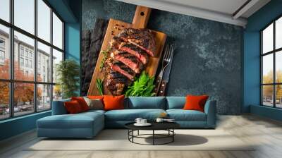 Sliced steak ribeye, grilled with pepper, garlic, salt and thyme served on a wooden cutting Board on a dark stone background. Top view with copy space. Flat lay Wall mural