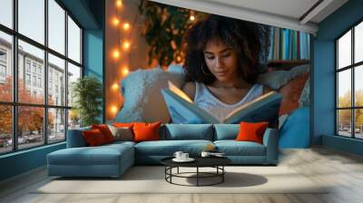 Young woman reading book in cozy evening setting, highlighting importance of literature and relaxation in student life Wall mural