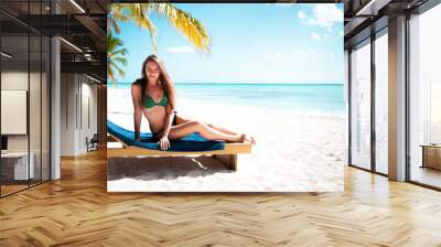 Young attractive blonde girl with perfect sport body in bikini on the tropical summer beach Wall mural