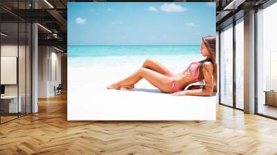 Young attractive blonde girl with perfect sport body in bikini on the tropical summer beach Wall mural