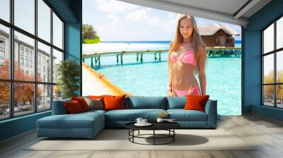 Young attractive blonde girl with perfect sport body in bikini on the tropical summer beach Wall mural